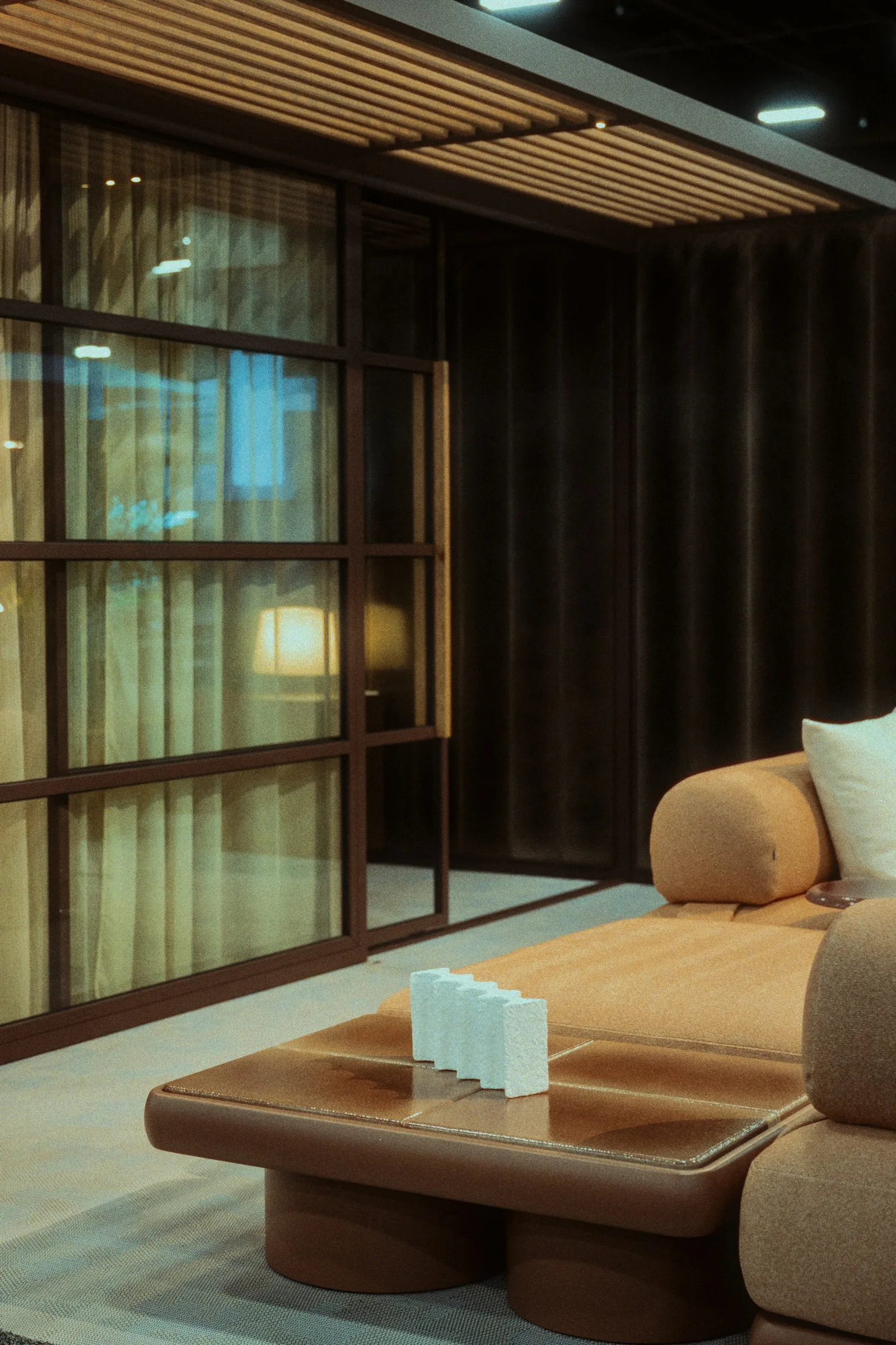 A sofa in an interior with tall glass windows.